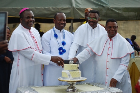 Bishop Badejo with the Silver Jubilarians and Msgr Yakubu cutting the anniversary cake.