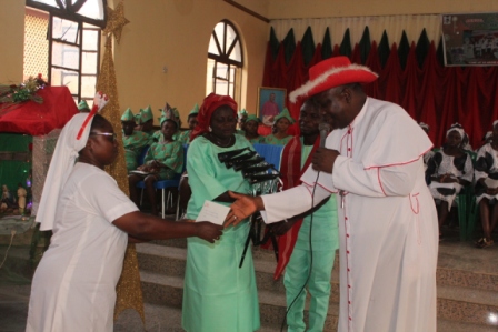Bishop Badejo assisted by Rev Sr Eunice Ikufisile OSF during the presentation of gifts to the choir of St Stephen's Apaara.