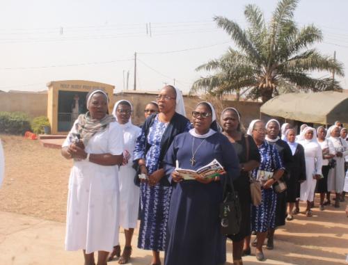 The Consecrated persons processing into the Church with candle light