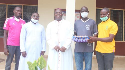 The farm manager, Agricultural Development Initiative (CADI), Mr Iyiola Gabriel presenting the first production from the poultry session to Bishop Emmanuel Badejo with the JDPM Coordinator, Fr. Gabriel Adeleke and other CADI members