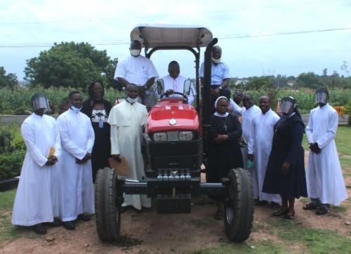 Most Rev Emmanuel Badejo flanked by some priests and religious of Oyo Diocese after blessing the Tractor.